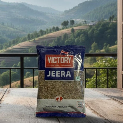 Bag of Victory Jeera on a wooden table with a scenic view of mountains through large windows.