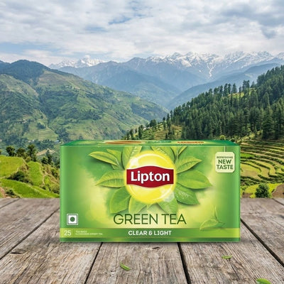 Lipton Green Tea box on a wooden surface with a scenic mountain background