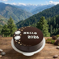 Chocolate cake with 'Hello 2026' text against a mountainous landscape