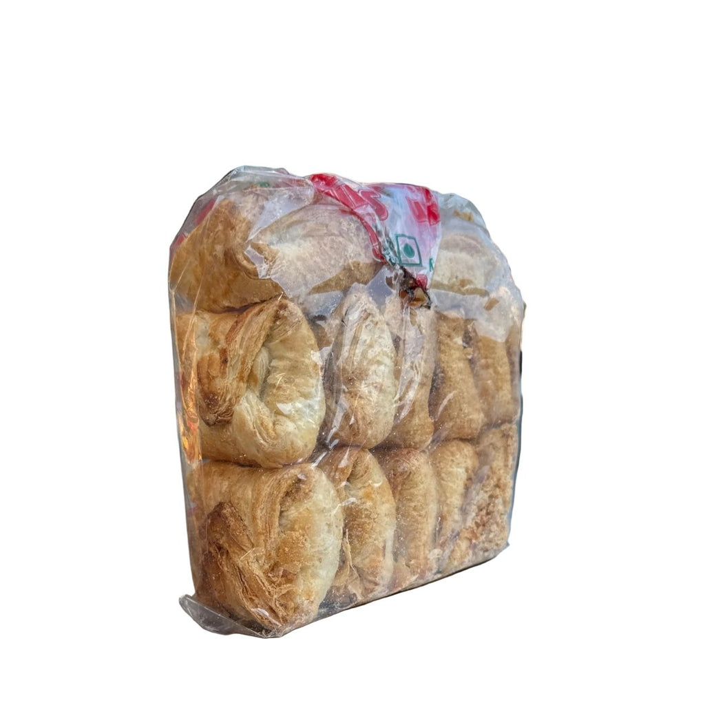 Packaged bread on a metal surface with a blurred outdoor background
