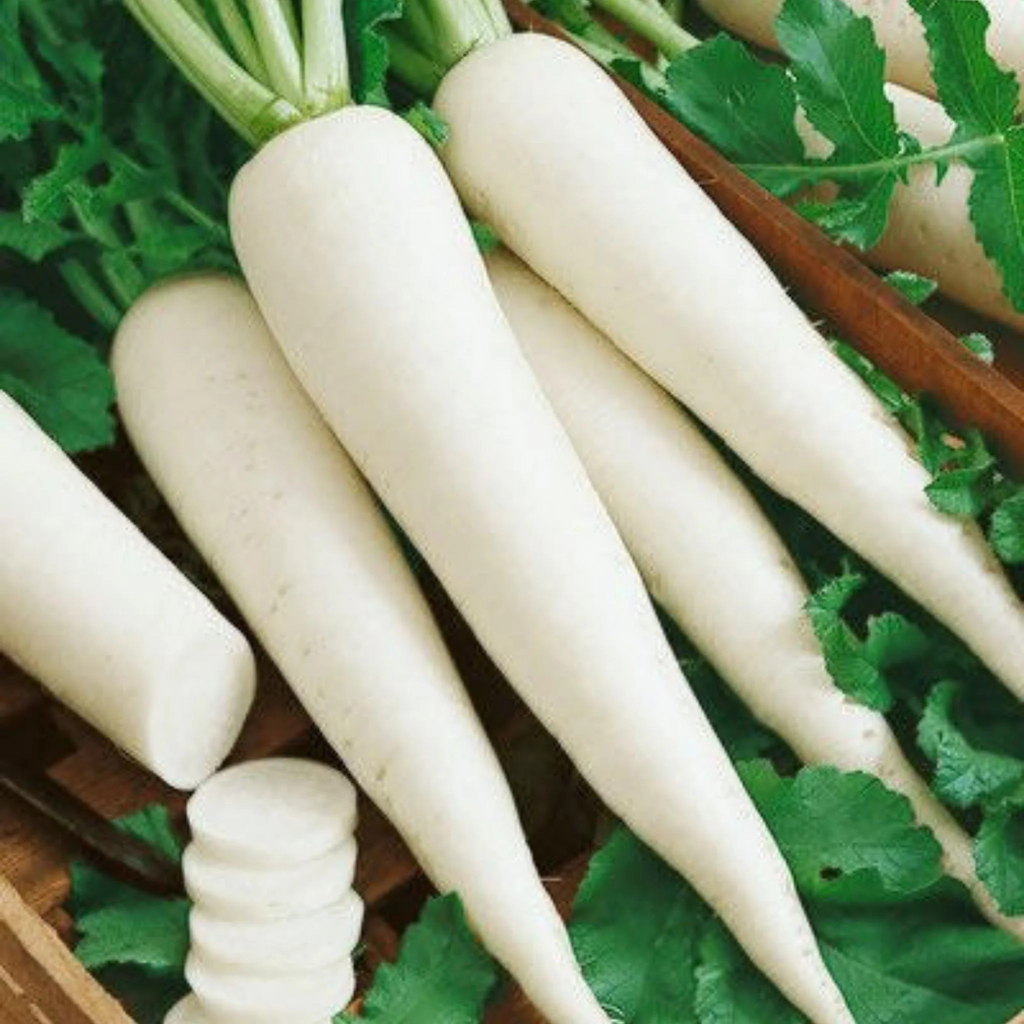 White radishes with green leaves on a wooden surface