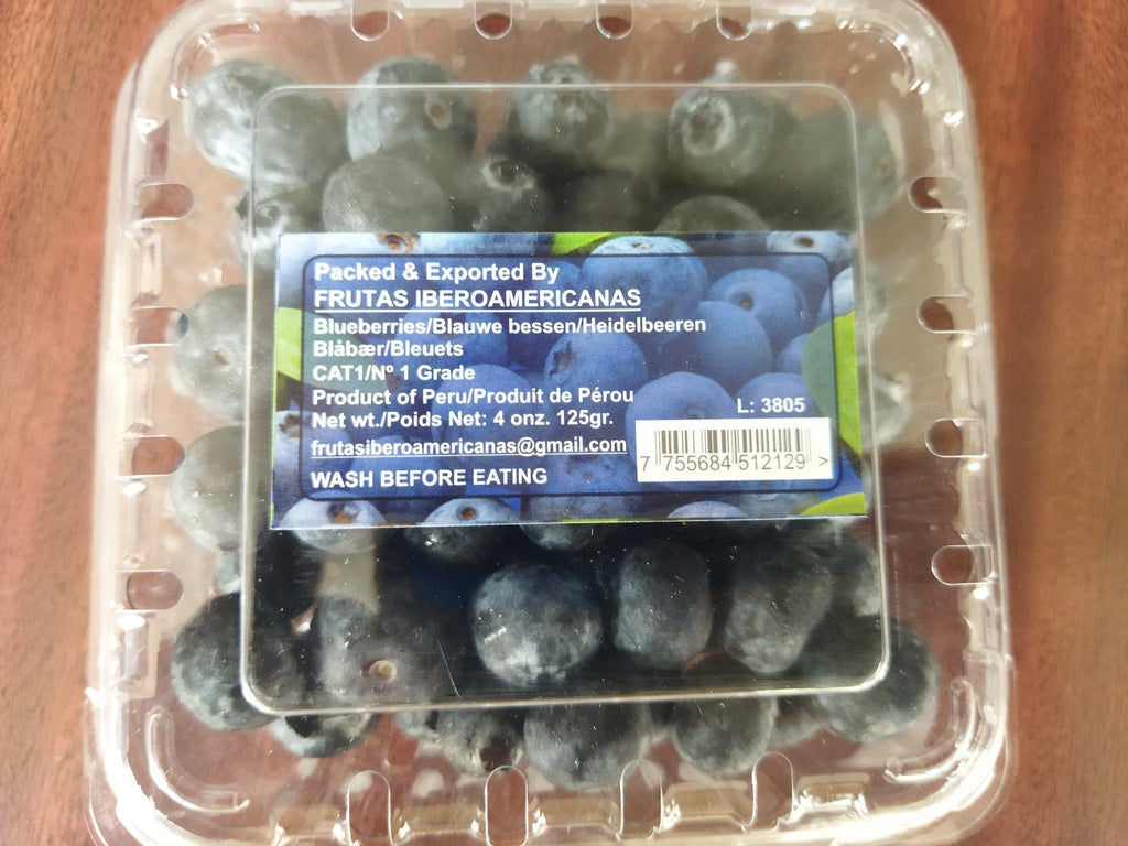 Packaged blueberries with a label on a wooden surface
