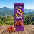 Cadbury Dairy Milk Silk Bubbly chocolate bar with a scenic background of mountains and trees.