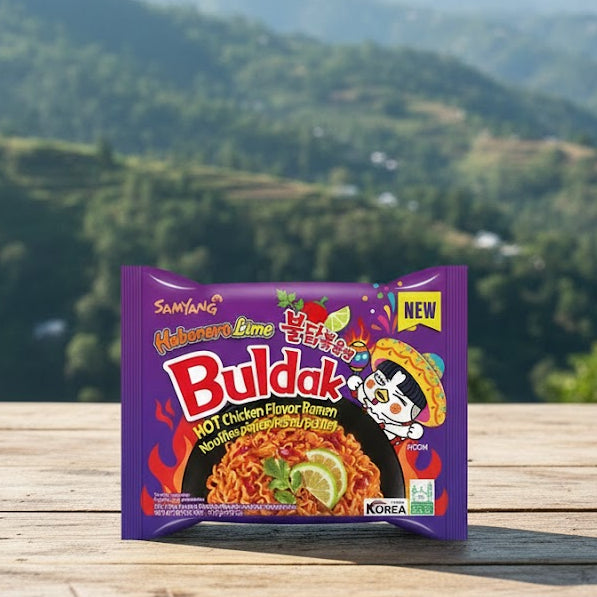 Buldak instant noodles package on a wooden surface with a mountainous landscape in the background