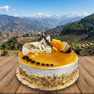 Cake with decorative elements on a wooden surface with a mountainous landscape in the background