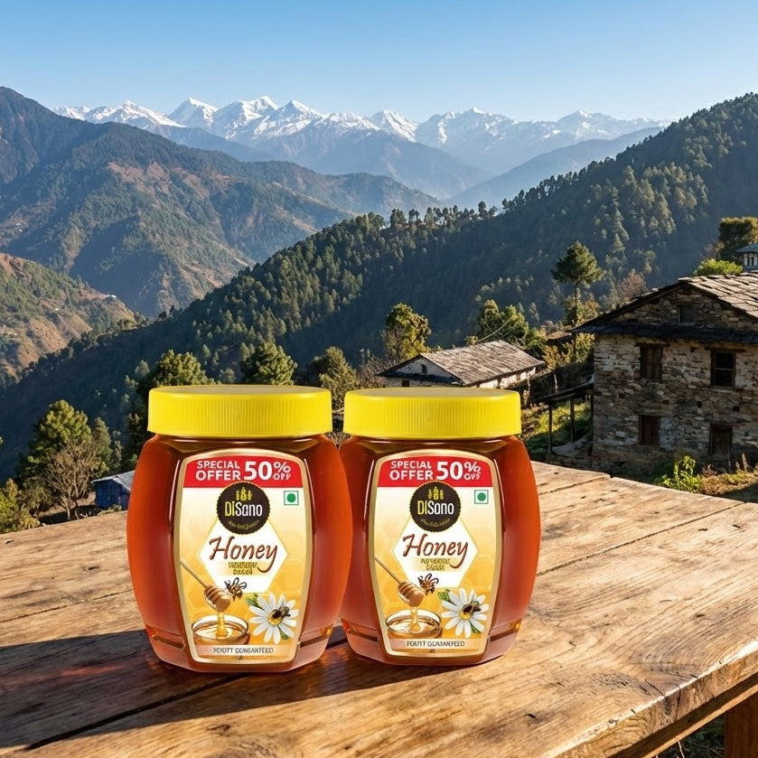 Two jars of honey on a wooden table with a mountainous landscape in the background
