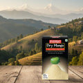 Everest Dry Mango box on a wooden surface with a scenic mountain landscape in the background
