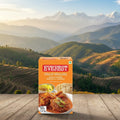 Everest Meat Masala packaging on a wooden surface with a mountainous landscape in the background
