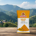 MDH Haldi Powder packet on a wooden surface with a scenic mountain background