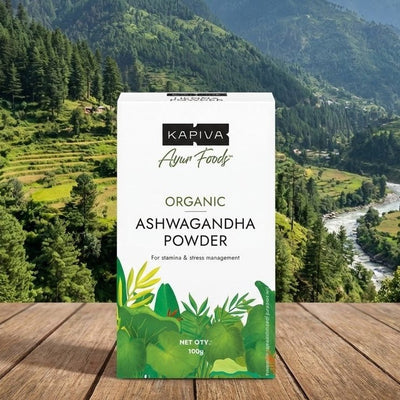 Kapiva Organic Ashwagandha Powder package on a wooden surface with a mountainous landscape in the background