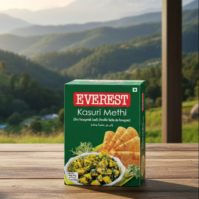 Box of Everest Kasuri Methi on a wooden table with a scenic mountain view in the background