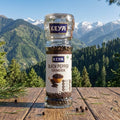 KEYA black pepper grinder on a wooden surface with a mountainous landscape in the background