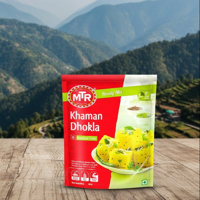 MTR Khaman Dhokla packaging on a wooden surface with a mountainous landscape in the background