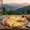 Cheese pizza with a slice missing on a wooden table with a scenic mountain view.