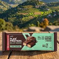 Max Protein Millet Wafers bar on a wooden table with a scenic mountain view in the background