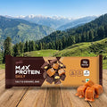 Max Protein Daily salt & caramel bar packaging with a mountainous landscape in the background