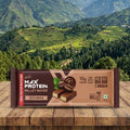 Max Protein Millet Wafer package on a wooden surface with a mountainous landscape in the background