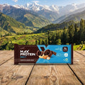 Max Protein bars on a wooden surface with a mountainous landscape in the background