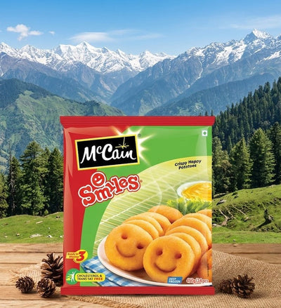 Packaging of McCain Smiles potato products with a mountainous landscape in the background