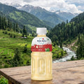 Mogu Mogu bottle on a wooden table with a scenic mountain landscape in the background