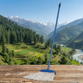 Mop on a wooden surface with a scenic mountain landscape in the background