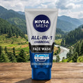 Nivea Men All-in-1 Charcoal Face Wash tube with a scenic background of mountains and trees.