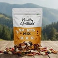 Bag of Nutty Gritties Sports Mix on a wooden surface with a mountainous landscape in the background
