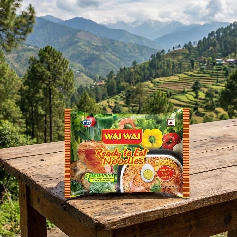 Wai Wai ready-to-eat noodles package on a wooden table with a scenic mountain background