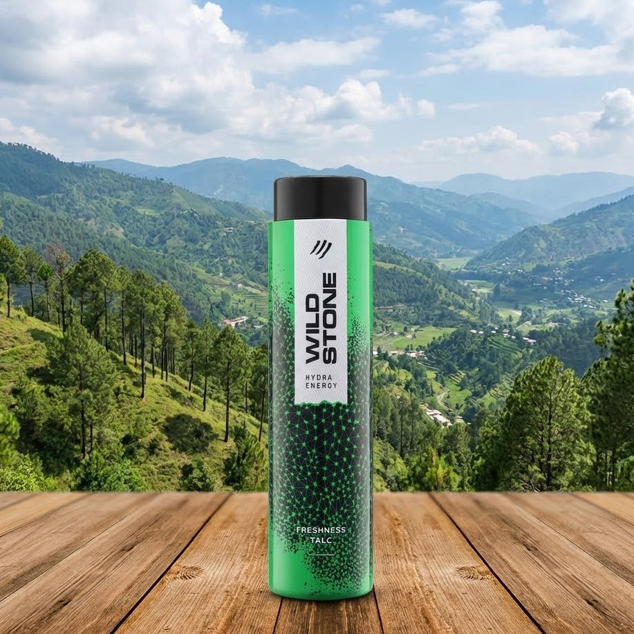 Green bottle with black cap on a wooden surface with a scenic mountain background