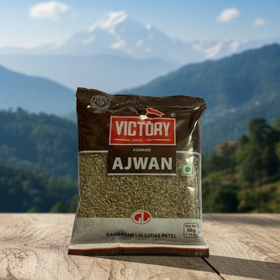 Package of Victory Ajwan seeds on a wooden surface with a mountainous landscape in the background
