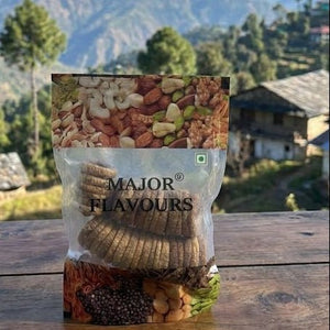 Packaged dried fruits on a wooden surface with a mountainous landscape in the background