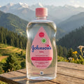 Bottle of Johnson's baby product on a wooden table with a mountainous landscape in the background