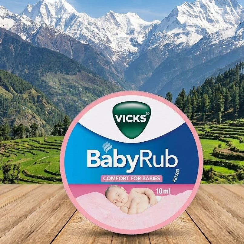 Vicks BabyRub container on a wooden surface with a scenic mountain background