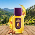 Bajaj Almond Drops bottle with almond nuts on a wooden surface with a mountainous background