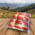 Packaged bread on a wooden surface with a scenic mountain background