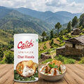 Catch Sprinkler Chat Masala can with bowls of food on a wooden surface, mountainous landscape in the background