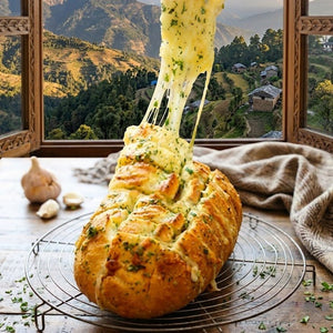 Cheesy bread with stringy cheese being pulled, set against a scenic window view of mountains.