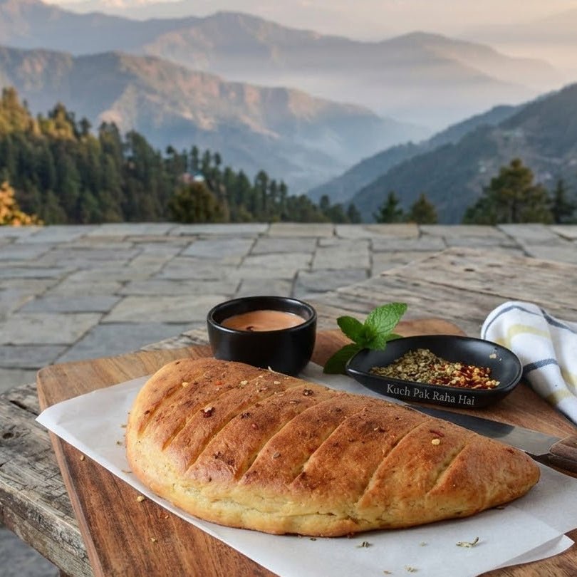 Loaf of bread on a wooden table with a scenic mountain view in the background