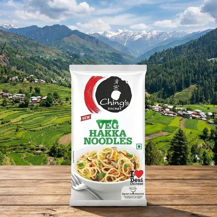 Ching's Secret Veg Hakka Noodles package with a scenic mountain background