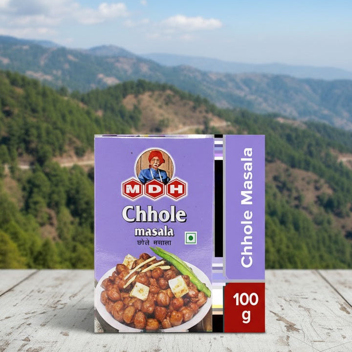 Box of MDH Chhole masala with a mountainous landscape in the background
