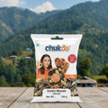 Chukde Garam Masala packet on a wooden surface with a mountainous landscape in the background