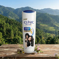 Clinic Plus shampoo bottle with a scenic background of mountains and greenery.
