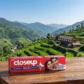 Closeup toothpaste box on a wooden table with a scenic mountain background