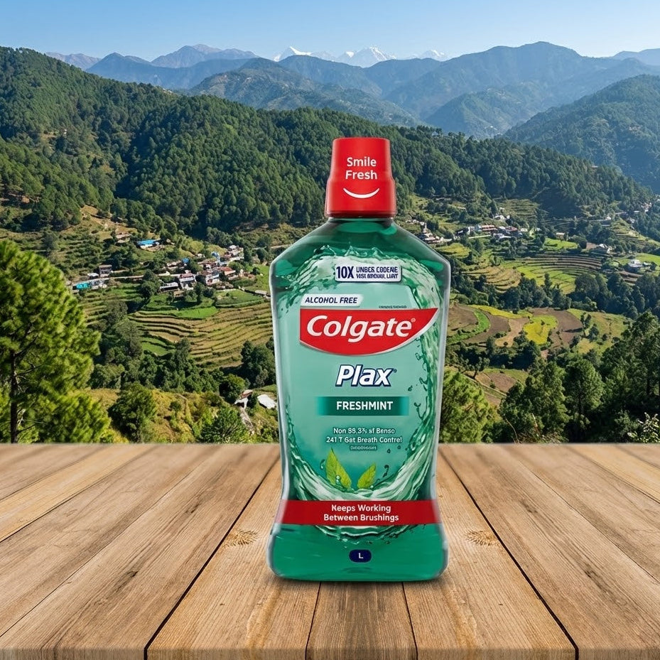 Colgate Plax Freshmint mouthwash bottle on a wooden surface with a mountainous landscape in the background