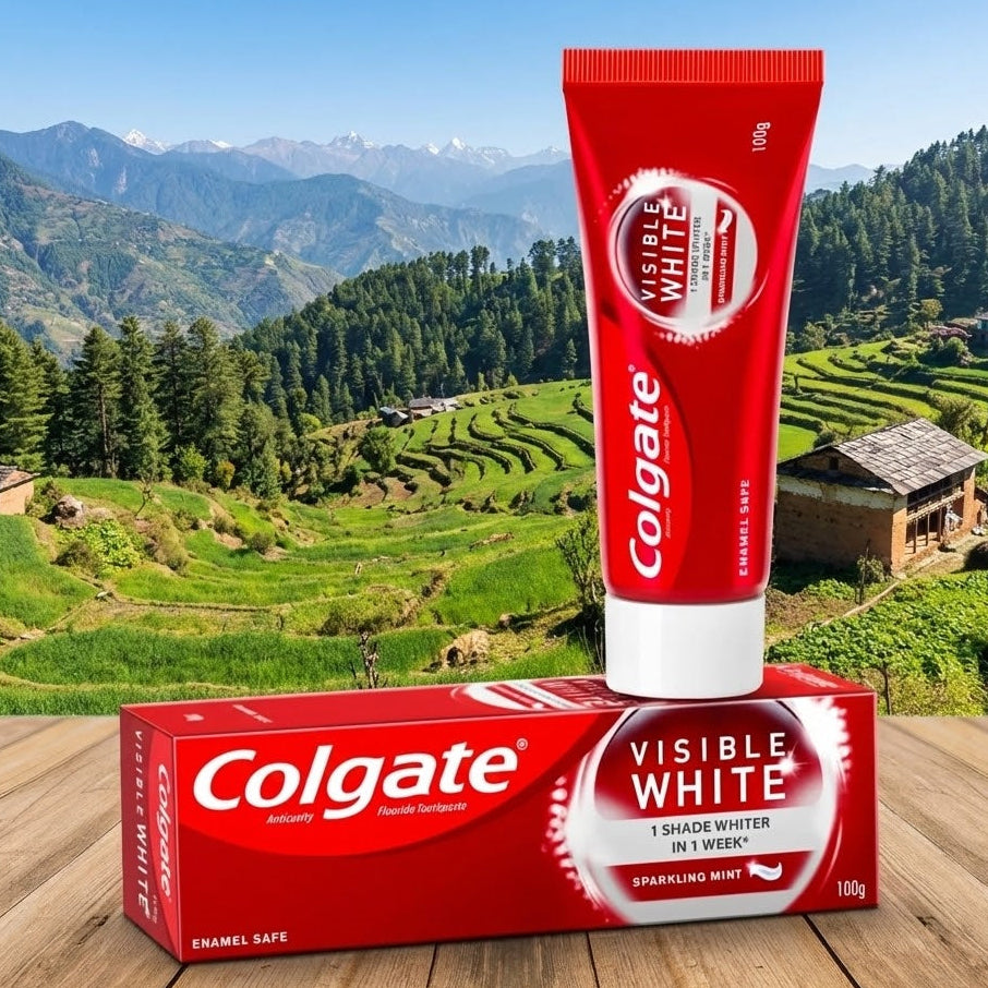 Colgate Visible White toothpaste tube and packaging on a wooden surface with a scenic background