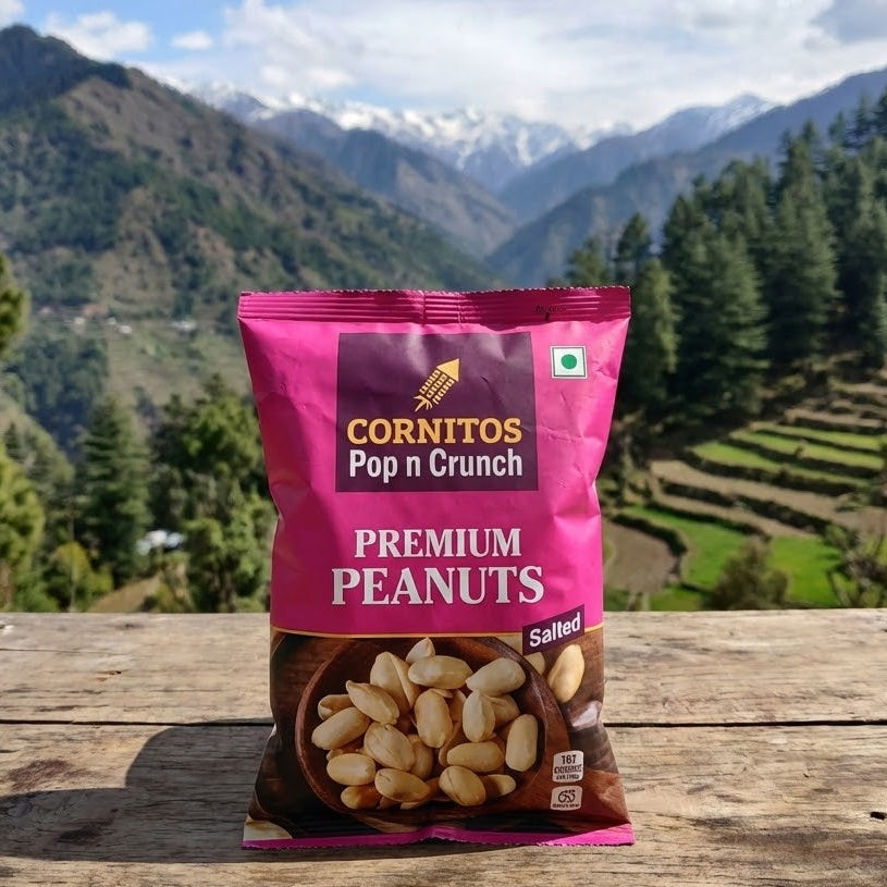 Cornitos Pop n Crunch Premium Peanuts packet on a wooden surface with a mountainous landscape in the background