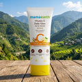Mamaearth Vitamin C Daily Glow Face Wash tube with a scenic background