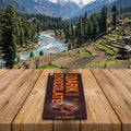 Chocolate bar packaging on a wooden surface with a scenic mountain landscape in the background