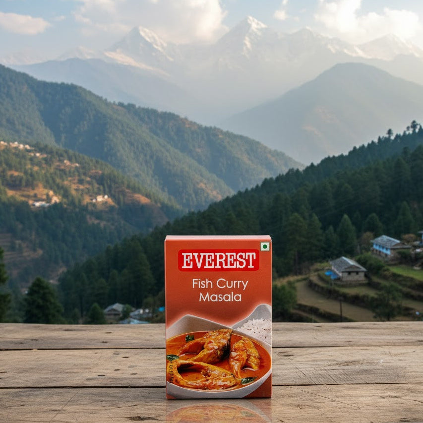 Box of Everest Fish Curry Masala on a wooden surface with a mountainous landscape in the background