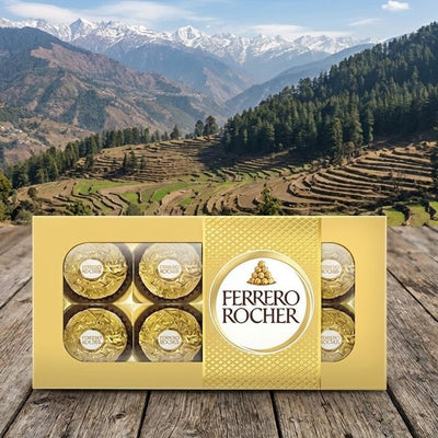 Ferrero Rocher chocolate box on a wooden surface with a mountainous landscape in the background